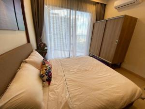 um quarto com uma cama e uma grande janela em Timurbay Seafront Residence aRRayyan Suites em Kuantan