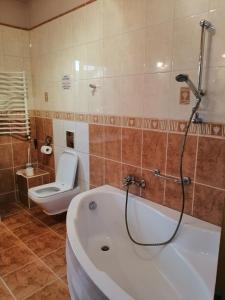 a bathroom with a bath tub and a toilet at Delfin in Mielno