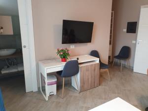 a room with a desk with chairs and a tv on a wall at B&B BcenS "La città delle 100 sculture" - Belpasso - Etna in Belpasso