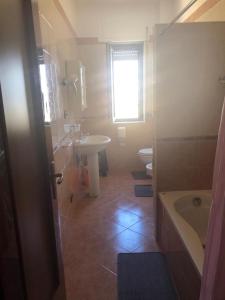 La salle de bains est pourvue d'un lavabo, d'une baignoire et de toilettes. dans l'établissement Il Girasole, à Crotone