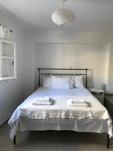 Vegera Apartment 'Ostria', Stavros Donoussa في دونوسا: غرفة نوم بسرير ابيض عليها منشفتين