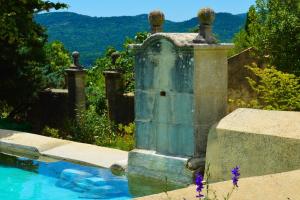 una fuente en medio de una piscina en un patio en La Bastide Du Claus - Vitaverde, en Cruis