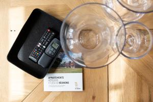 eine Fernbedienung und ein Glas Wein auf dem Tisch in der Unterkunft HARAS DE BARRY in Sainghin-en-Mélantois