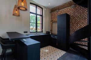 a kitchen with a sink and a brick wall at HARAS DE BARRY in Sainghin-en-Mélantois