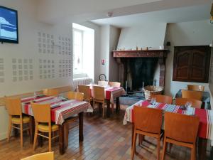 comedor con mesas y sillas y chimenea en Hotel des Remparts, en Saint-Jean-Pied-de-Port