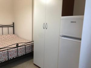 1 dormitorio con armario blanco junto a la cama en Bianchito Sea, en Peschici