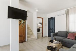 a living room with a couch and a tv on a wall at Villa Flamboyan in Yaiza