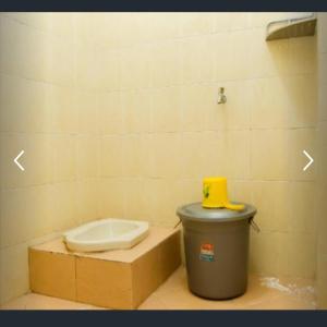 een badkamer met een toilet en een vuilnisbak bij Penginapan Sriwijaya in Tanjungpandan