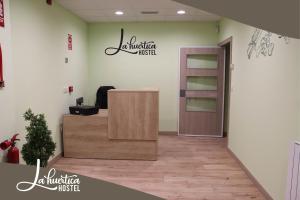 an office with a reception desk with a sign on the wall at Hostel La Huertica in Valtierra
