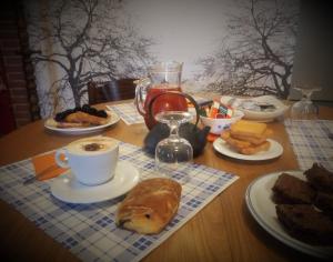 a wooden table with a breakfast of coffee and bread at L'Elefantino - Bed and Book in Roccasparvera