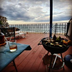 - un barbecue sur une terrasse avec vue sur l'eau dans l'établissement Котеджі на приватному пляжу - Совіньон 2024, à Odessa