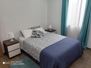 a bedroom with a bed with a blue blanket at Varandas do Basalto in Queimada