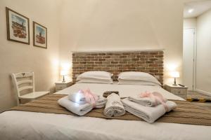a bedroom with a bed with towels and a brick wall at BandBFirenze 8 Cittadella 8 in Florence