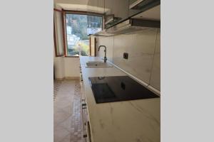 een keuken met witte marmeren werkbladen en een wastafel bij La Casa di Principino in Giglio Porto