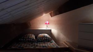 a small bed with a lamp on top of it at Les Bergians in Beuil