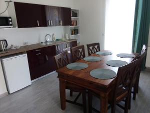a kitchen with a wooden table with chairs and a kitchen with a sink at Willa Brodnica in Brodnica Dolna