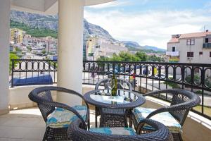 una mesa y sillas en un balcón con vistas en Delux Apartman Jukic, en Makarska