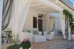 patio con muebles blancos y dosel blanco en Agriturismo Salinola en Ostuni