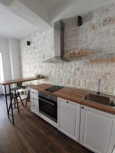a kitchen with white cabinets and a sink and a table at Apartments Kut in Vis