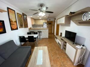 ein Wohnzimmer mit einem Sofa und einem Tisch in der Unterkunft Playa Gandia, Iris, piscina AA y WiFi in Gandía