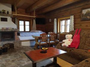 a living room with a teddy bear sitting on a couch at Chata POD DUBEM in Plavy
