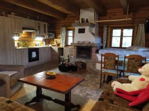 a living room with a table and a kitchen with a fireplace at Chata POD DUBEM in Plavy