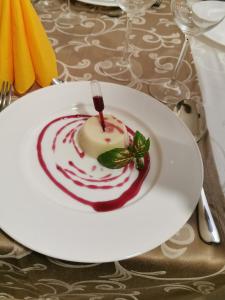 a white plate with a dessert on a table at Pensiunea JOJO Imperial Resort&Spa in Băile Herculane