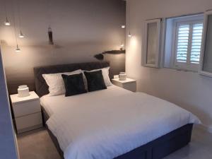 a bedroom with a large white bed with two night stands at Olive Grove House Lumbarda in Lumbarda