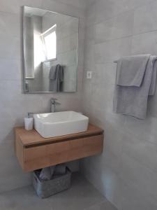 a bathroom with a sink and a mirror and towels at Olive Grove House Lumbarda in Lumbarda