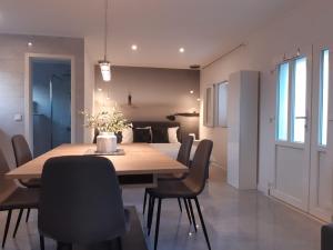 a dining room with a wooden table and chairs at Olive Grove House Lumbarda in Lumbarda