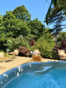 a swimming pool with chairs and trees in the background at The Devonian in Ilfracombe