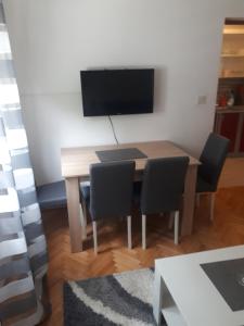 mesa de comedor con sillas y TV de pantalla plana en Apartments Mamich, en Kaštela