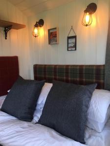 a bed with two pillows on it in a room at 40 Bernisdale - Shepherds Hut in Skeabost