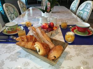 a table with a plate of bread and a bowl of fruit at Le Douétaux chambres d'hotes in La Baussaine