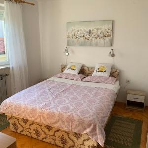 - une chambre avec un lit et une couette rose dans l'établissement Apartment Lucija, à Novi Vinodolski
