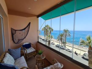a living room with a large window with a view of the ocean at Marina Habanera in Almuñécar