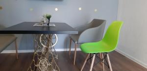 a dining room table with four green chairs at Apartments Jack in Bihać