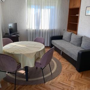 a living room with a table and a couch at Apartment Lucija in Novi Vinodolski