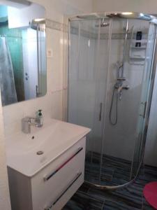 y baño con ducha y lavamanos. en Apartment Lucija, en Novi Vinodolski