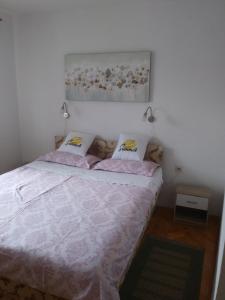 a bedroom with a large bed with pink sheets at Apartment Lucija in Novi Vinodolski +17 photos