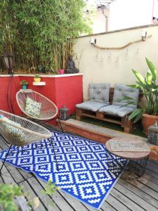 un patio con 2 sillas y una alfombra azul y blanca en La Chamberte, en Villeneuve-lès-Béziers