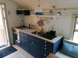 a kitchen with blue cabinets and a sink at Guesthouse Gjoel in Gjøl