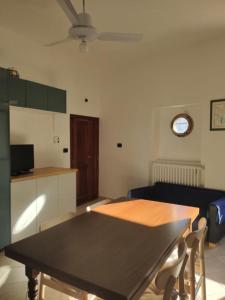 a living room with a table and a kitchen at La Casa di Principino in Giglio Porto