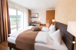 ein Hotelzimmer mit einem großen Bett und einem Fenster in der Unterkunft Hotel Amaris in Olten