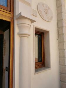 eine weiße Säule auf einem Gebäude mit Fenster in der Unterkunft B&B Casa Dilillo in Foggia