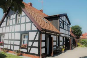 a black and white building with a red roof at Dom Gościnny Flauta II in Ustka