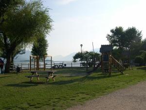 a park with a bench and a playground at Residence Miralago Rooms & Apartments in Manerba del Garda