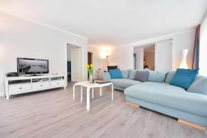 salon z niebieską kanapą i telewizorem w obiekcie Villa Grenzschlösschen 01 w mieście Ahlbeck