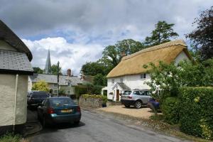 a small village with cars parked on a street at Old Inn House in Kings Nympton