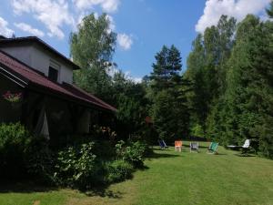 a yard with chairs and a house at Mazurskidom Zapiecek in Świętajno